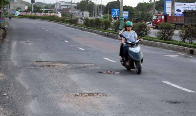 Một người lái xe máy vì né ổ gà mà tràn qua phần đường ô tô